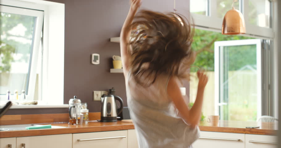 Happy, dance and woman in a kitchen with music, freedom and celebration while streaming at home. Energy, fun and excited female person with good mood, moving or listening to radio groove in a house Royalty-Free Stock Footage #3438734973