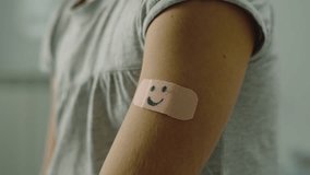 Close up of a doctor's hand putting plaster on a little girl's arm.
the patch has the design of a smiley face.
Prevention, medicine and vaccines concept. - Powered by Shutterstock - Get 15% off with code: PIKWIZARD15