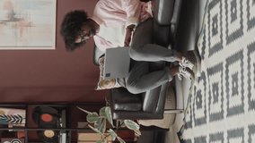 Vertical full shot of young creative ethnically diverse couple of talented interior designers with dog creating ideas while working from stylish home office together, sitting on black leather couch - Powered by Shutterstock - Get 15% off with code: PIKWIZARD15