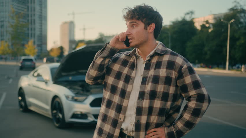 Worried stressed man driver Caucasian guy talk mobile phone calling car service engine problem stand on road outdoors broken car background vehicle breakdown damaged automobile wreck need help in city Royalty-Free Stock Footage #3438814645