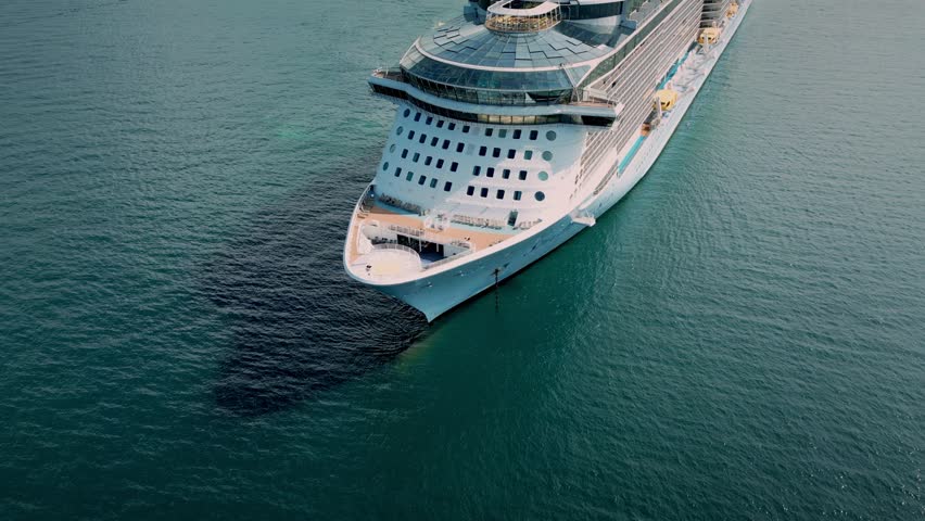 Flying over a large cruise ship at sea, off the coast of Vietnam, the city of Nha Trang. Aerial side view of a cruise ship sailing the ocean or sea on a sunny summer day.