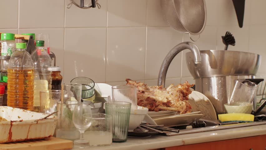 Scraps, Bones and goose or chiken skeleton on dirty dishes and mess after a party at home close-up. Christmas table after the holiday celebrating. Cleaning the house after dinner with friends and
