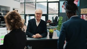 Retail assistants selling clothes to elderly client at fashion boutique, giving discount coupon to regular customer. Employees team assisting senior man to buy clothing items on sale. Camera B. - Powered by Shutterstock - Get 15% off with code: PIKWIZARD15