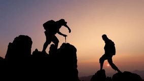 Silhouettes of two people climbing on mountain and helping. Teamwork of two men hiker helping each other on top of mountain climbing team beautiful sunrise. Help and assistance concept. - Powered by Shutterstock - Get 15% off with code: PIKWIZARD15