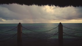 Rainbow after the storm. Sunset view of Caribbean sea and tropical beach from wooden pier, Punta Cana resort