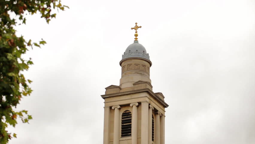 Downward panning view of the steeple of a church in London, England.