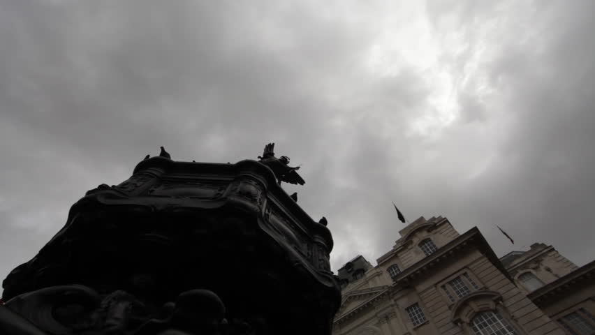 Birds flying and landing on the Eros statue in London