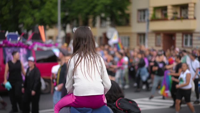 Little kid sit father shoulder. Gay protest against no homophobia. Family walk lgbt pride parade. Child watch lesbian strike. Bi parent show csd fest girl daughter. Peaceful rally crowd. Fun festival Royalty-Free Stock Footage #3439047205