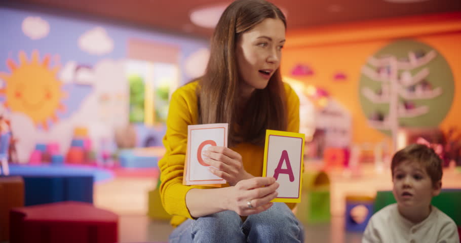 Cheerful Daycare Teacher Using Gaming and Acting Methods to Teach Multiethnic Kids Alphabet in Kindergarten. Small Cute Boys and Girls Getting Basic Reading and Writing Skills, Learning Alphabet