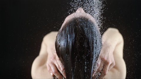 Beautiful woman head showering shampoo rinse in slow Motion. head woman close up rinsing out shampoo under shower on black  background