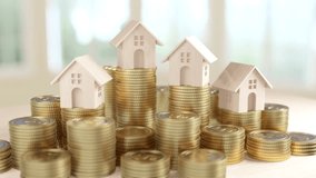 This image showcases multiple wooden house models placed on increasing stacks of coins, representing the concept of growth in real estate investment, highlighted by a natural light setting. - Powered by Shutterstock - Get 15% off with code: PIKWIZARD15