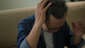 Upset asian senior man worried about problem, unhappy elderly man feeling annoyed, retired man stress and burn out together with touching his head, mental health problem in retirement. - Powered by Shutterstock - Get 15% off with code: PIKWIZARD15