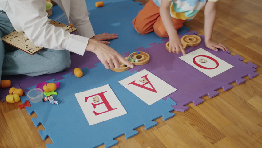 Child learning letters with therapist in educational play session. Early childhood education and development concept. Interactive learning environment for design and print - Powered by Shutterstock - Get 15% off with code: PIKWIZARD15