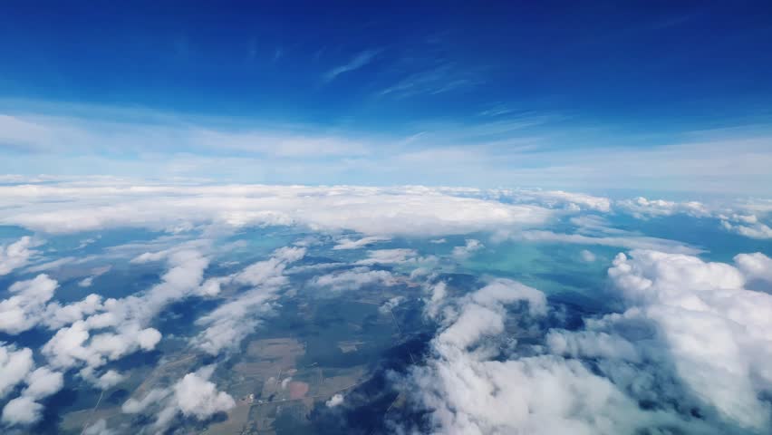 VARADERO, CUBA - DECEMBER 20, 2023: View from the porthole on the Atlantic coast of Cuba. View of the turquoise ocean water and islands with snow-white sand from the plane. White clouds over the water