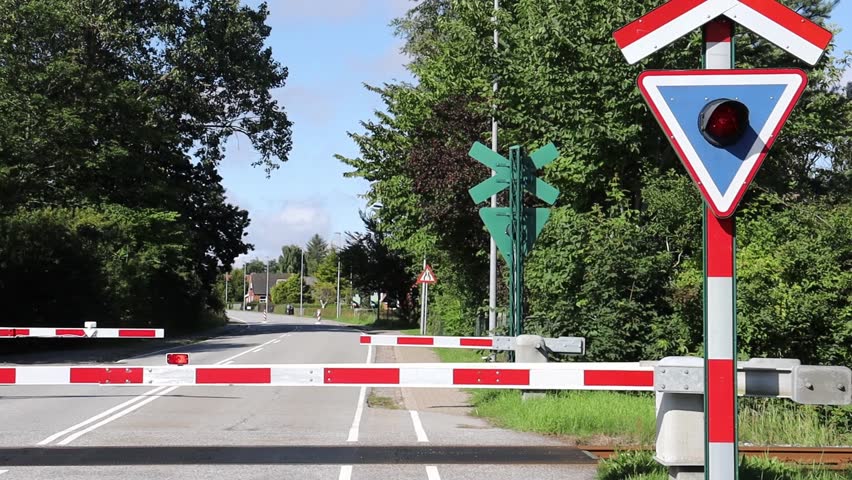 Traffic light with red light at a closed railway crossing.