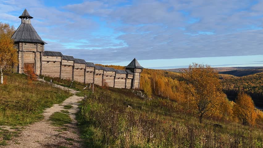 The scenery for the film The Heart of Parma in the Perm region. A large log fortress in the open air in the golden autumn. Autumn panoramic view of the fortress in the rays of the sun.