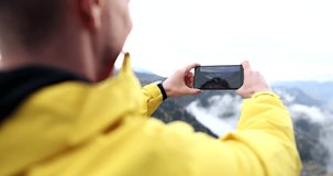 Man traveler taking pictures on mobile phone mountains closeup 4k movie slow motion. Mobile photography concept