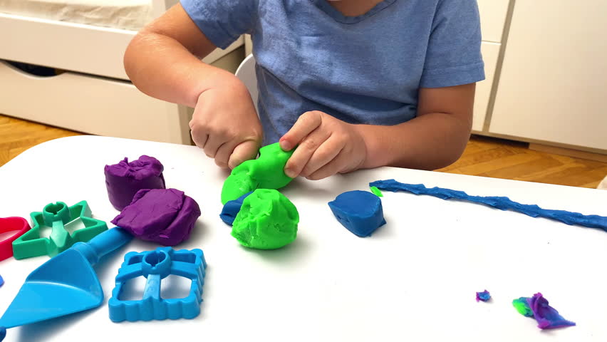 child boy playing at home,molding colored plasticine.Kid sculpts with clay stucco.Play dough.art creativity,craft at kindergarten.Development of fine motor skills.sensory education.