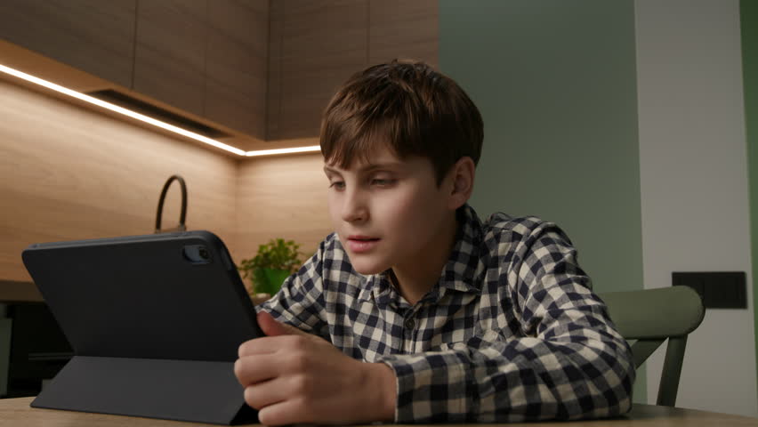 Autistic Boy Engaged in Online Lesson via Tablet. Learning Through Screens. Royalty-Free Stock Footage #3439458171