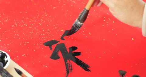Writing chinese calligraphy with word meaning luck for lunar new year Arkivvideo