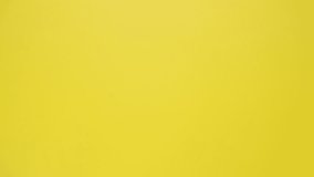 Stop motion animation of crumpled paper, stop motion animation 4k, on a yellow background.