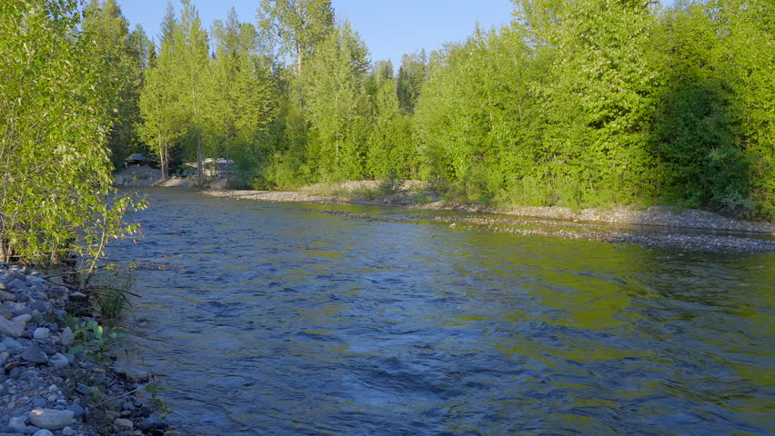 Establishing shot of majestic mountain river with mountain background in Vancouver, Canada, North America. Day time on April 2023. Still camera view. ProRes 422 HQ.