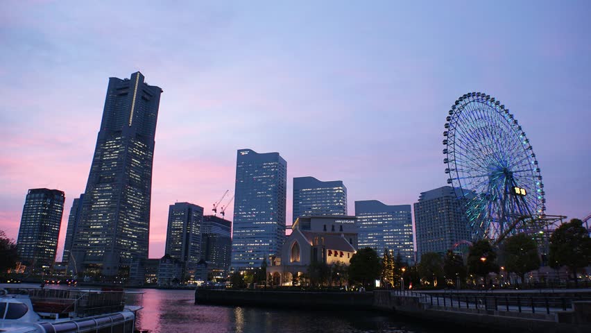 SAKURAGICHO, YOKOHAMA, JAPAN - APR 2022 : View of cityscape of “Minatomirai“ area in sunset. Urban downtown area in central Yokohama city. View of buildings around the harbor or port or bay.
