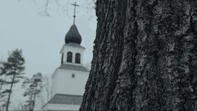 Christian Church Cross in a snowy landscape with a picturesque backdrop of trees, captured in a cinematic video.
