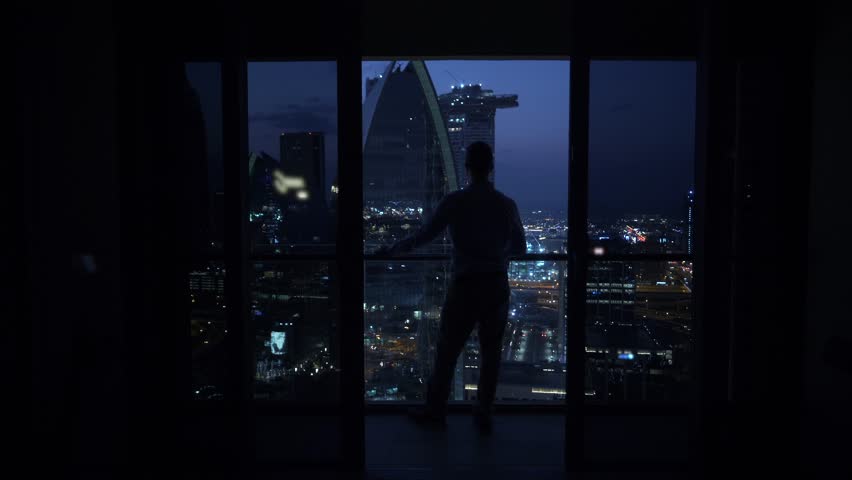 Young Man Succeed In High Rise Apartment Looking at Urban Buildings