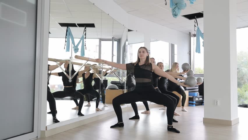 Women dancing in mirror at dance studio for fun and entertainment.