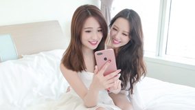 two beauty woman selfie happily on the bed