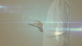 Animation of network of connections over caucasian male doctor in hospital. Global connections, medicine, healthcare and digital interface concept digitally generated video.
