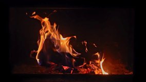 Orange flames engulf logs in a fireplace, captured in slow motion for a dramatic and cozy effect.