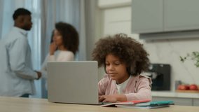 African American kid girl school pupil daughter child in headphones studying online home e-learning watching class lesson listening tutor by video call remote education at kitchen parents talk family