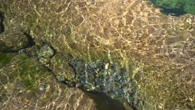 Summer relaxing background with copy space for text water waves in slow motion over natural rocks. High quality 4k footage
