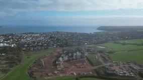 Paignton, South Devon, England: DRONE VIEWS: The drone circles a new build housing development under construction on green belt land at White Rock. Paignton is a popular UK holiday resort (Clip 4).