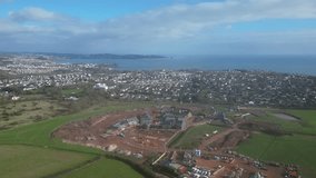 Paignton, South Devon, England: DRONE VIEWS: The drone circles a new build housing development under construction on green belt land at White Rock. Paignton is a popular UK holiday resort (Clip 3).