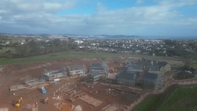 Paignton, South Devon, England: DRONE VIEWS: The drone circles a new build housing development under construction on green belt land at White Rock. Paignton is a popular UK holiday resort (Clip 2).
