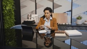 Focused African American architect evaluating plans, immersed in her work at a contemporary office setting. Businesswoman analyzing blueprints, reflecting the meticulous nature of her profession - Powered by Shutterstock - Get 15% off with code: PIKWIZARD15