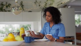 Female nurse or doctor getting ready for work in the morning, eating breakfast and having cup of coffee, before leaving for the work dressed in scrubs. Work-life balance for healthcare worker. - Powered by Shutterstock - Get 15% off with code: PIKWIZARD15