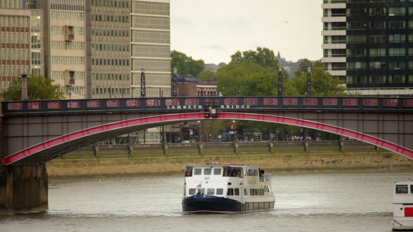 A shot of Lambeth Bridge with cars and red double decker buses going across it
