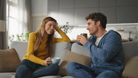 Chatting duet drinking tea at sofa interior closeup. Calm woman sipping tea cup listening husband at cozy apartment. Love pair discussing daily news relaxing couch at weekend. People home lifestyle  - Powered by Shutterstock - Get 15% off with code: PIKWIZARD15