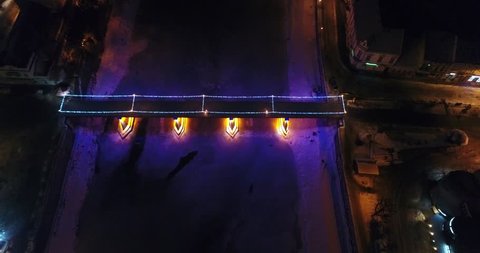 Aerial view: Fire Theater near the illuminated bridge on frozen river, 4k