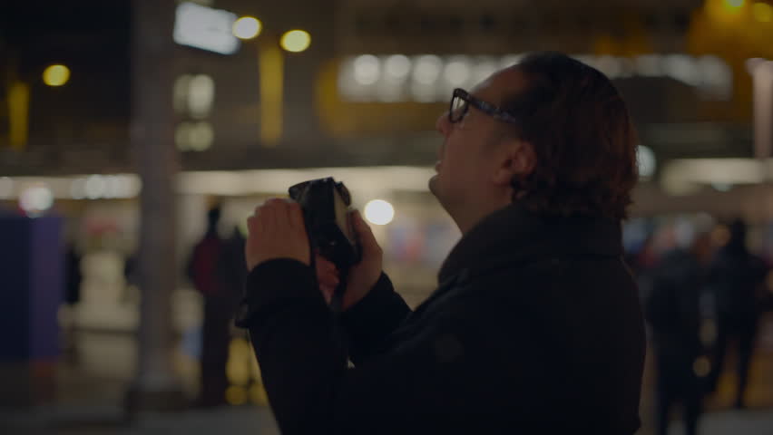 Street Photographer Capturing Pictures of People Traveling at Night