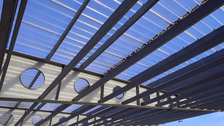 Metal structures of a sun canopy against a blue sky.