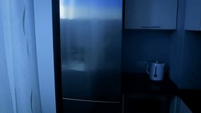 Slow motion video of young sleepy woman taking food from refrigerator at night