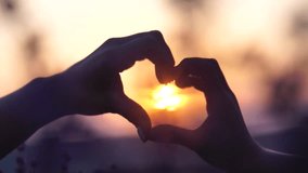 Sunset, silhouette, love - Hands form heart shape, Mother and daughter hand-in-hand move amidst purple flora. Happy Lady enjoys sunny day, wandering in lavender field, appreciating nature. - Powered by Shutterstock - Get 15% off with code: PIKWIZARD15