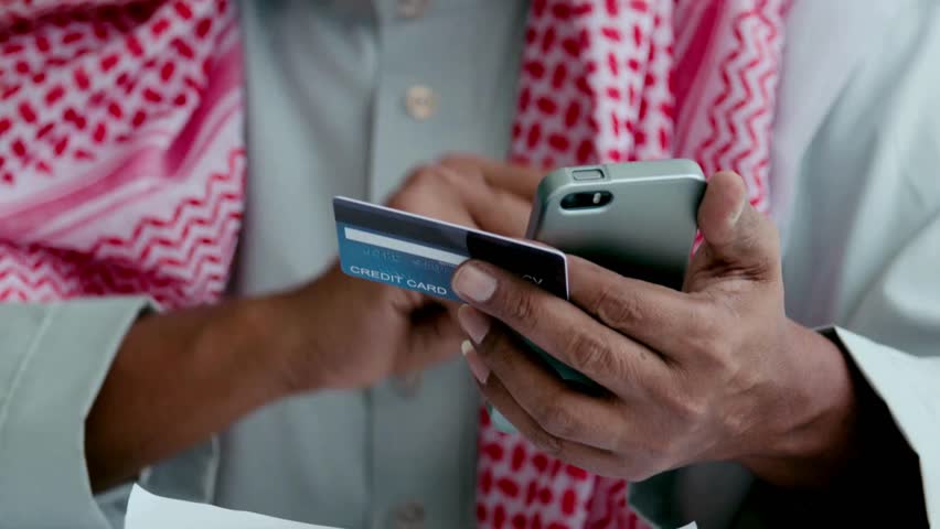 arab person in living room for digital banking Online purchases and use of sofa Using credit card and digital phone to buy online shopping debit Royalty-Free Stock Footage #3440502575