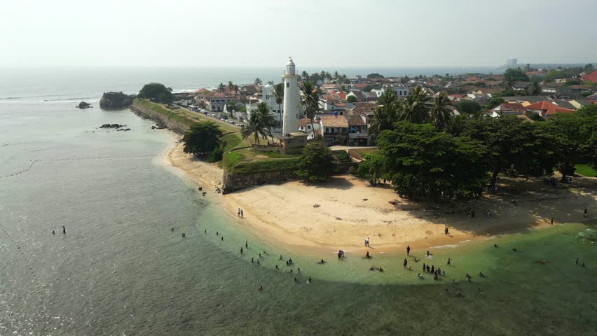 Galle Dutch Fort with colonial architecture and lighthouse by the coast of the ocean aerial view Royalty-Free Stock Footage #3440543325