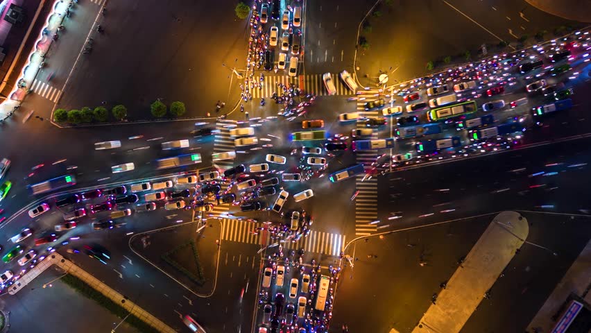 Vertical video. Aerial time-lapse of evening traffic at intersection in Ho Chi Minh City, Vietnam. Royalty-Free Stock Footage #3440545387